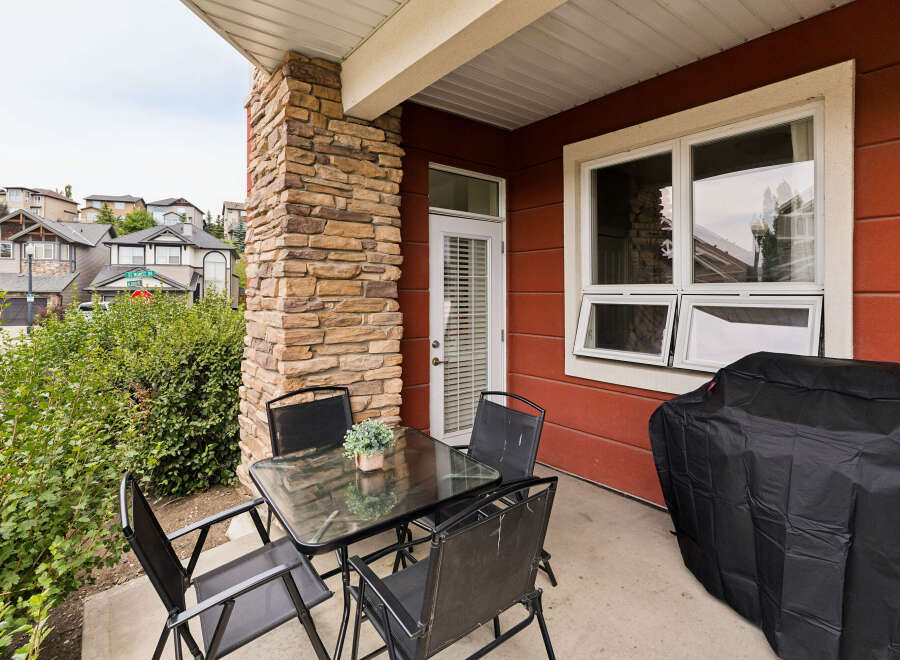 Enjoy outdoor living on this charming patio featuring a glass-top dining table with four chairs, perfect for al fresco meals.