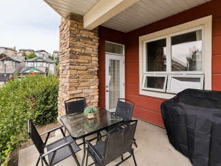 Enjoy outdoor living on this charming patio featuring a glass-top dining table with four chairs, perfect for al fresco meals.