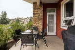 Enjoy outdoor living on this charming patio, complete with a glass-top dining table and four black mesh chairs, perfect for al fresco meals.