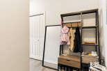 Welcome guests into a stylish entryway featuring a modern coat rack with ample storage and hanging space for jackets and accessories.