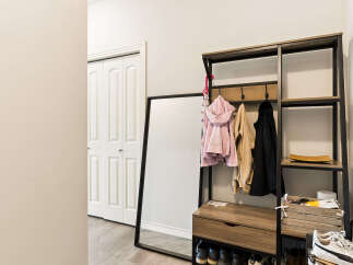 Welcome guests into a stylish entryway featuring a modern coat rack with ample storage and hanging space for jackets and accessories.
