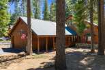 Nestled amidst tall pine trees, this charming wooden cabin offers a serene mountain retreat.