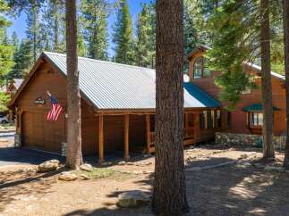 Nestled amidst tall pine trees, this charming wooden cabin offers a serene mountain retreat.
