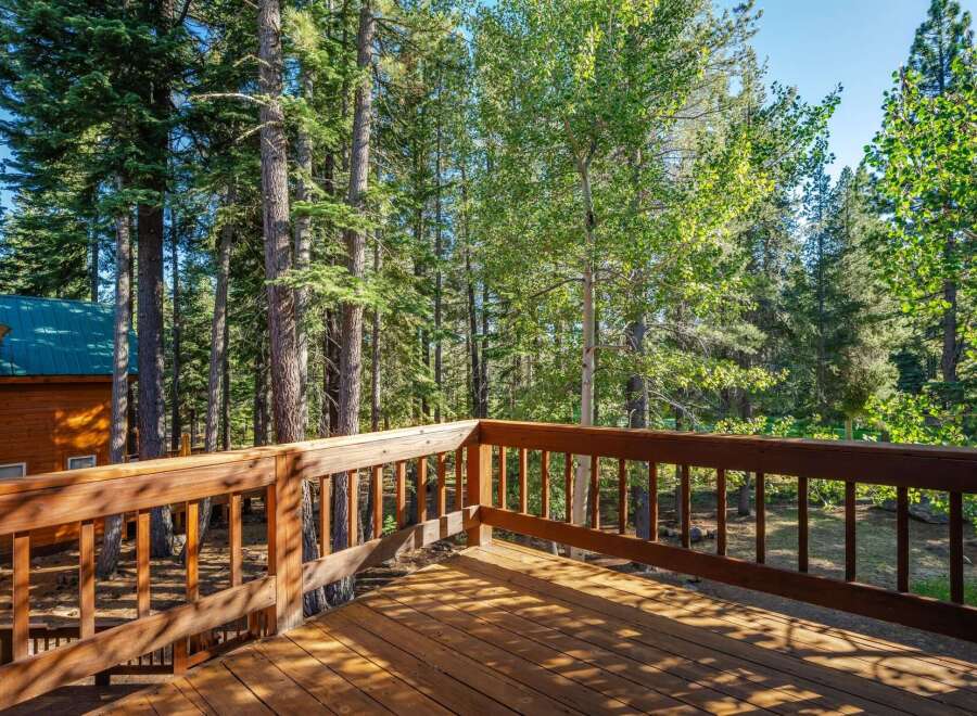 Enjoy the serene mountain setting from this charming wooden deck, perfect for outdoor relaxation and entertaining.