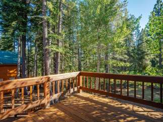 Enjoy the serene mountain setting from this charming wooden deck, perfect for outdoor relaxation and entertaining.