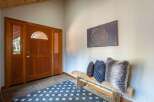 Step into this inviting entryway featuring a beautiful wooden door with a decorative glass transom, setting a warm and welcoming tone.
