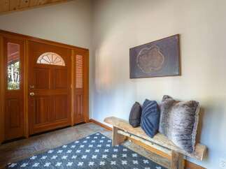 Step into this inviting entryway featuring a beautiful wooden door with a decorative glass transom, setting a warm and welcoming tone.