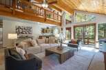 Experience rustic charm in this spacious living room, featuring a vaulted wood-beamed ceiling and a cozy loft overlooking the main area.