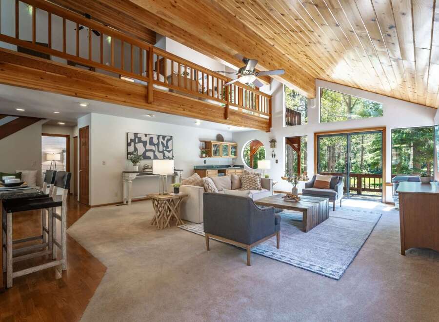 Experience rustic charm in this spacious living area featuring a vaulted wood-beamed ceiling and abundant natural light.