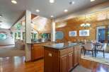 Experience the warmth of this inviting open-concept living space, featuring a stunning wood-paneled ceiling and walls that create a cozy, rustic ambiance.