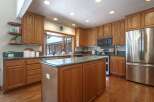 This spacious kitchen boasts beautiful oak cabinetry and granite countertops, offering ample storage and workspace.
