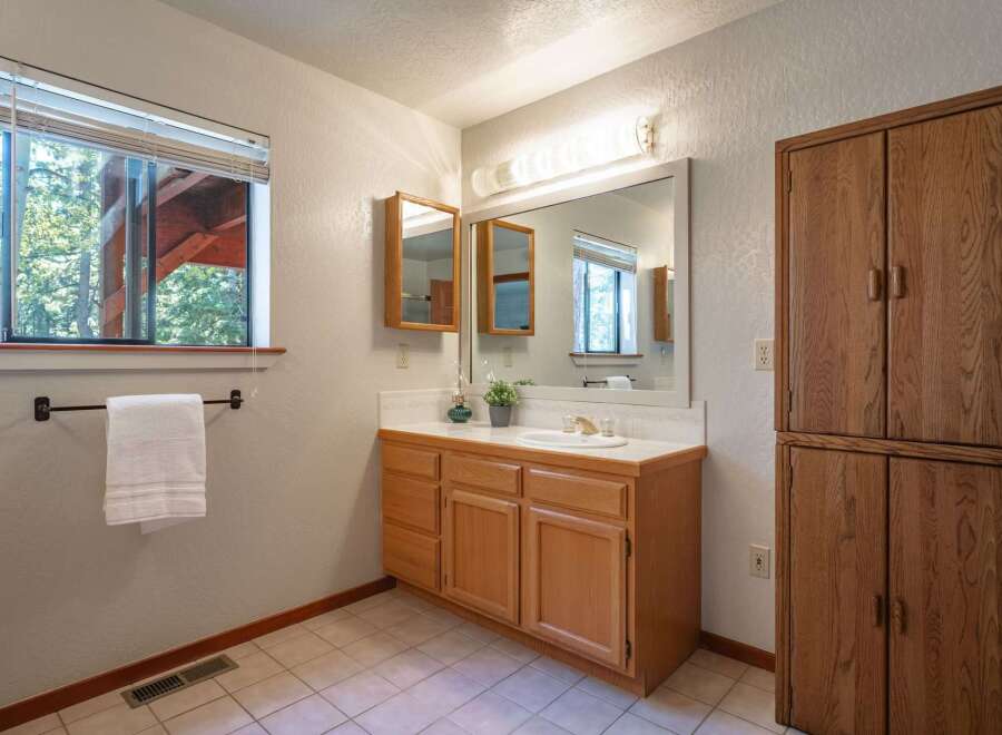 This bathroom features a spacious vanity with ample storage and a large mirror, perfect for your morning routine.