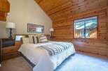 Experience rustic charm in this cozy bedroom, featuring a comfortable bed adorned with plush pillows and a decorative throw.