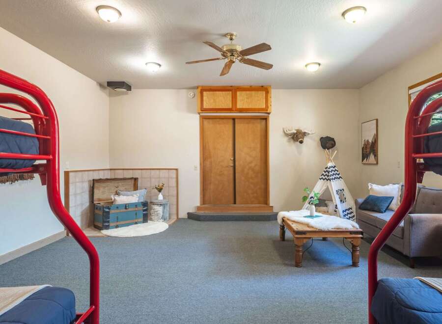 This versatile room features a playful teepee and bunk beds, perfect for a kids' play area or a unique guest room.