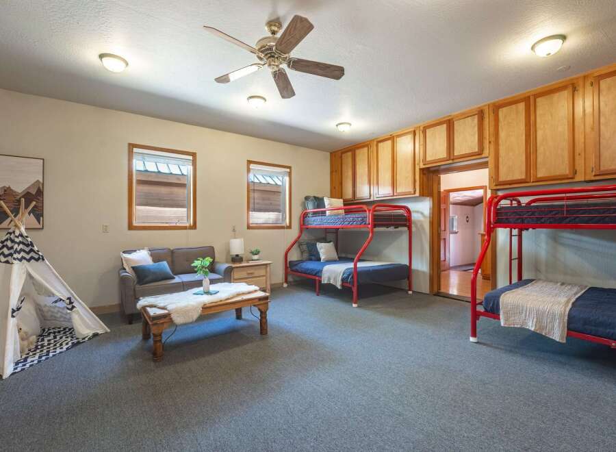 This versatile room offers ample sleeping arrangements with two sets of red bunk beds, perfect for accommodating guests or family.