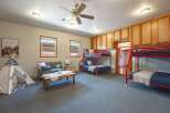 This versatile room offers ample sleeping arrangements with two sets of red bunk beds, perfect for accommodating guests or family.