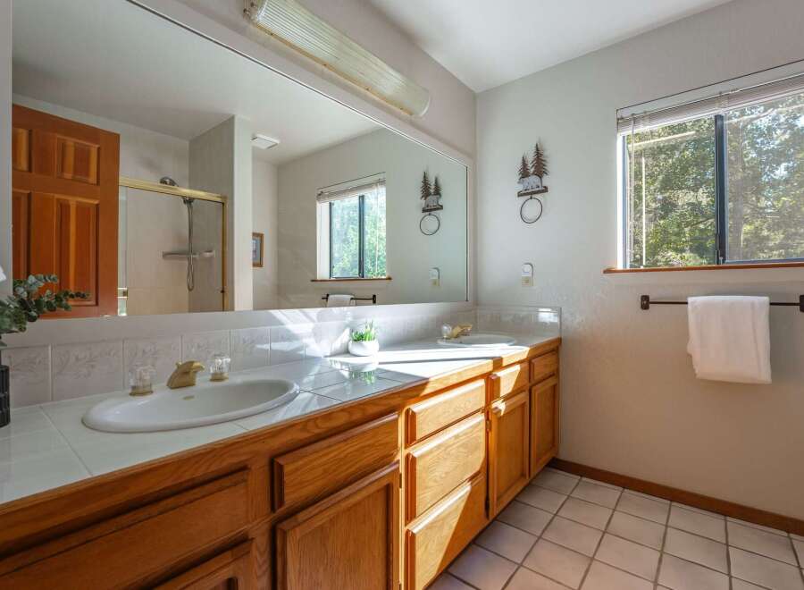 This bright and airy bathroom features a spacious double vanity with ample counter space and storage.