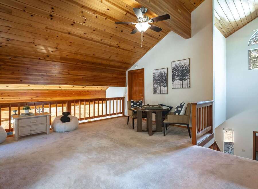 Ascend to this charming loft space, featuring a cozy seating area with a round table and chairs, perfect for games or intimate conversations.