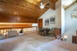 Ascend to this charming loft space, featuring a cozy seating area with a round table and chairs, perfect for games or intimate conversations.