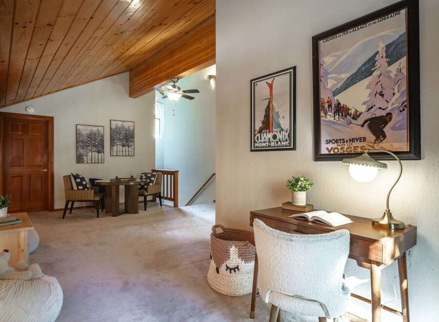 This charming living space features a vaulted wood-paneled ceiling and a cozy seating area with a round table and chairs, perfect for intimate gatherings.