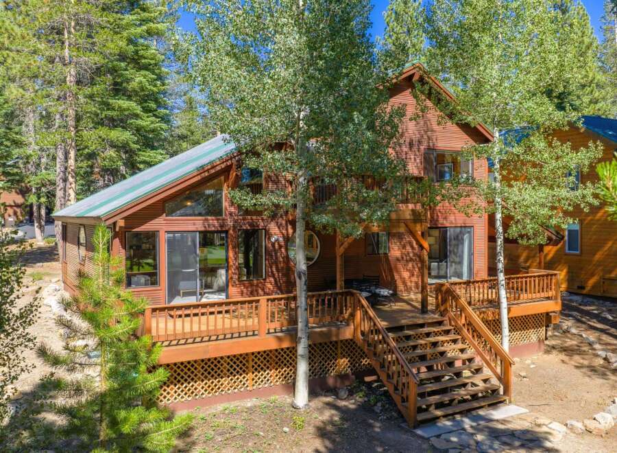 Experience mountain living in this stunning wooden home nestled among tall trees.