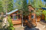 Experience mountain living in this stunning wooden home nestled among tall trees.