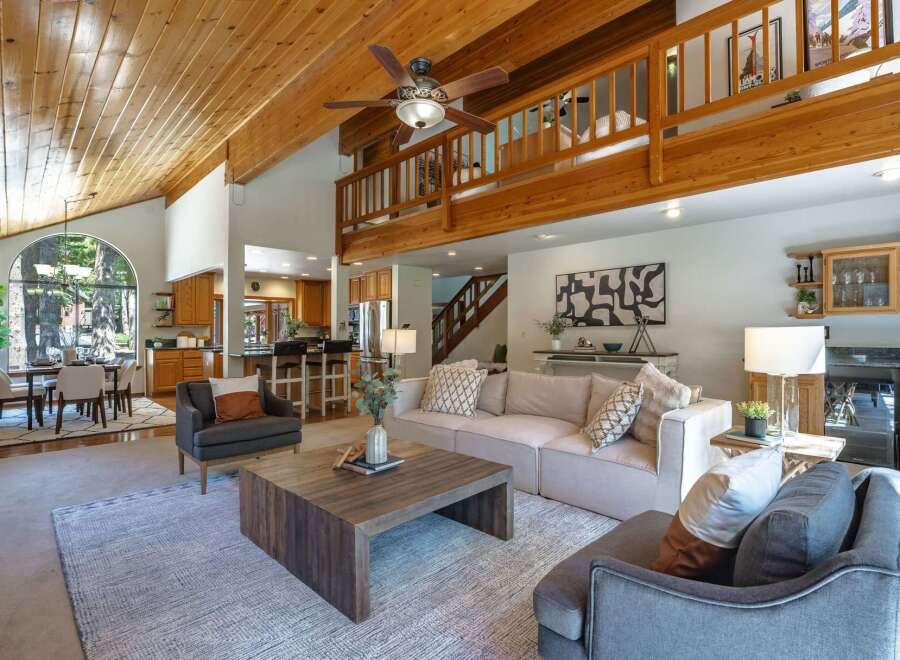 Experience the warmth of this stunning home featuring a vaulted wood-paneled ceiling and an open-concept living area.