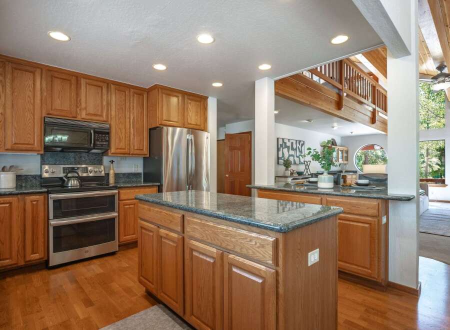 This spacious kitchen boasts beautiful oak cabinetry and granite countertops, perfect for any home chef.