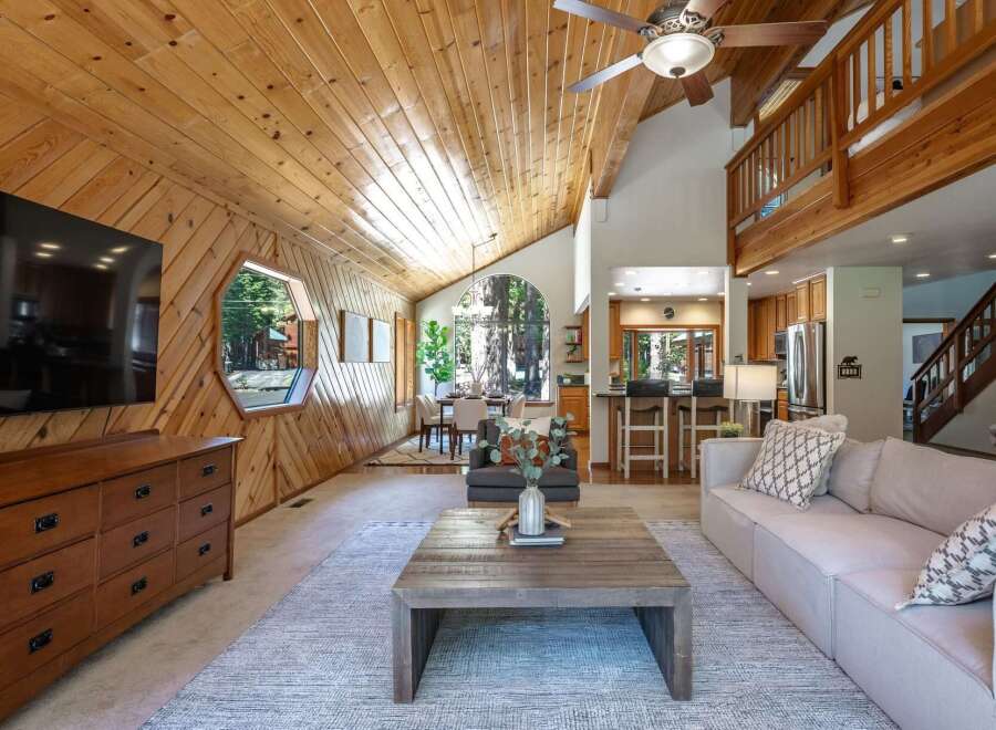 Experience rustic charm in this stunning mountain home featuring a vaulted wood-paneled ceiling and a unique hexagonal window offering picturesque views.