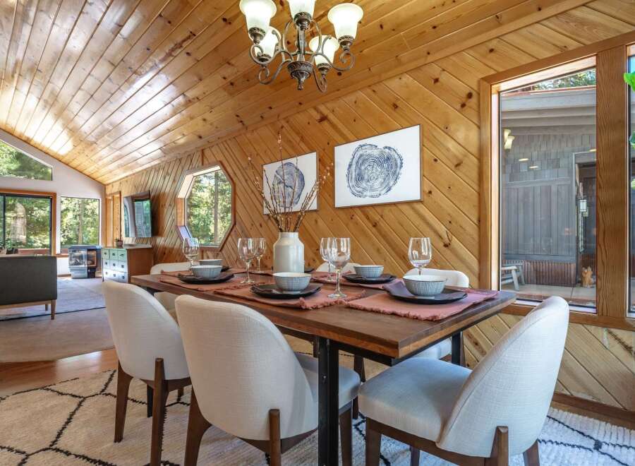 Experience rustic charm in this dining area featuring a warm, wood-paneled ceiling and walls that create a cozy ambiance.