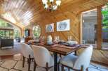 Experience rustic charm in this dining area featuring a warm, wood-paneled ceiling and walls that create a cozy ambiance.