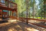 Enjoy the serene mountain lifestyle from this expansive wooden deck, perfect for outdoor dining and relaxation amidst towering trees.