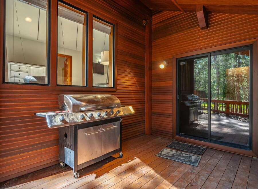 Enjoy outdoor living with this spacious deck featuring a large stainless steel grill, perfect for entertaining.