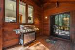 Enjoy outdoor living with this spacious deck featuring a large stainless steel grill, perfect for entertaining.