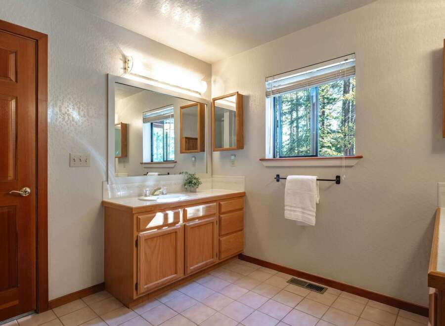 This bathroom features a warm oak vanity with ample storage and a spacious countertop, perfect for organizing your essentials.