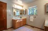 This bathroom features a warm oak vanity with ample storage and a spacious countertop, perfect for organizing your essentials.