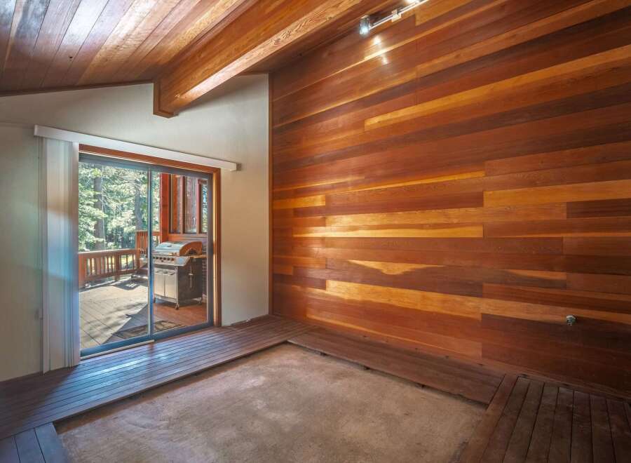 Experience rustic charm with this stunning interior featuring rich wood paneling on the walls and ceiling, creating a warm and inviting atmosphere.