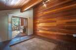 Experience rustic charm with this stunning interior featuring rich wood paneling on the walls and ceiling, creating a warm and inviting atmosphere.