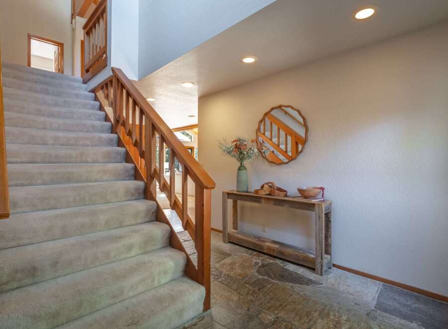 Ascend to the upper level via a plush carpeted staircase, complemented by a warm wooden banister.