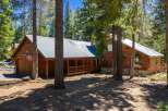 Nestled amidst towering pine trees, this charming wooden cabin offers a serene mountain retreat.