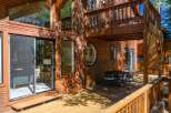 Experience rustic charm and modern comfort in this stunning wooden home, featuring expansive windows that invite natural light and scenic views.