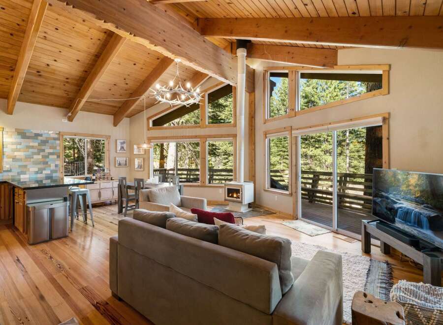 Experience the ultimate mountain retreat in this stunning cabin featuring a vaulted wood-beamed ceiling and a modern fireplace.