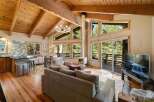 Experience the ultimate mountain retreat in this stunning cabin featuring a vaulted wood-beamed ceiling and a modern fireplace.