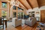 Experience cozy living in this mountain retreat featuring a stunning antler chandelier and a modern fireplace.