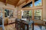 Experience rustic charm and natural beauty in this inviting dining area, featuring a sturdy wooden table and chairs perfect for family gatherings.