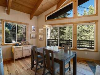 Experience rustic charm and natural beauty in this inviting dining area, featuring a sturdy wooden table and chairs perfect for family gatherings.