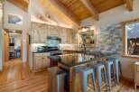Experience rustic charm in this mountain kitchen featuring light wood cabinetry and a spacious granite island with bar seating.