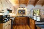 This charming kitchen boasts beautiful natural wood cabinetry and a rustic wooden ceiling with exposed beams.