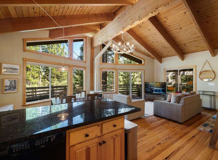 Experience mountain living in this stunning home featuring a spacious open-concept living area with vaulted wood-beamed ceilings and abundant natural light.