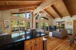 Experience mountain living in this stunning home featuring a spacious open-concept living area with vaulted wood-beamed ceilings and abundant natural light.